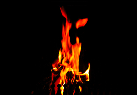 Pieces of wood burn in a warm fire at homeの写真素材