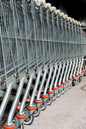 Queue of metal shopping carts left outside of the supermarketの写真素材