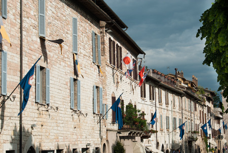 Houses with exposed bricks and neighborhood flags hanging on the walls on a day covered with gray cloudsの写真素材