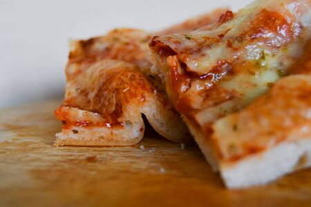 Two pieces of margherita pizza over a wooden table and on a white backgroundの写真素材