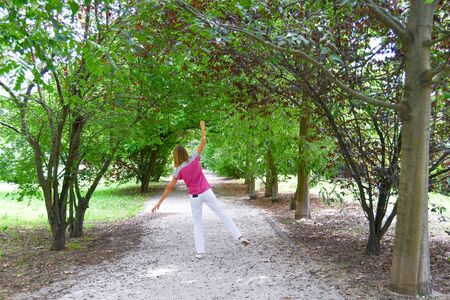 Woman happy and in harmony with nature with mobile phone in her pocket - Small break to enjoy nature without a devicesの写真素材