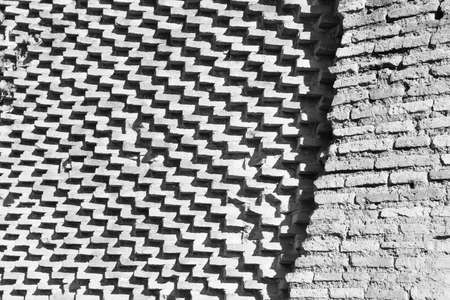 Bricks arranged differently in two walls, one staggered that draw zigzag and oblique lines and the other that draw horizontal linesの写真素材