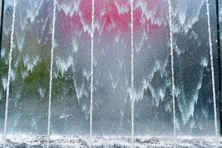 A lot of water coming down from a glass top and forming a graphic drawing with lines