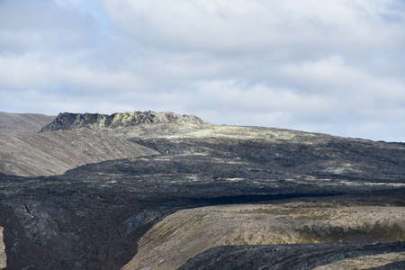 Stricie of black lava along the side of a volcano erupted in 2021 in Iceland on a cloudy dayの写真素材