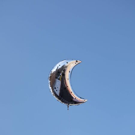Moon shape Balloons in the skyの写真素材