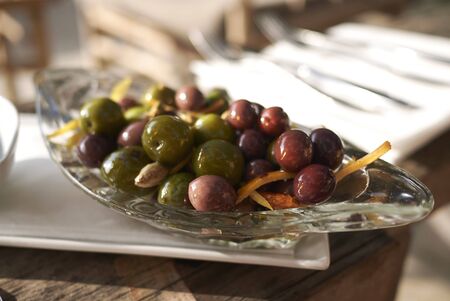 Red and green olives with lemon and orange zestの写真素材