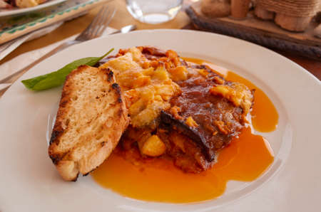 Parmigiana with aubergines and a slice of breadの写真素材