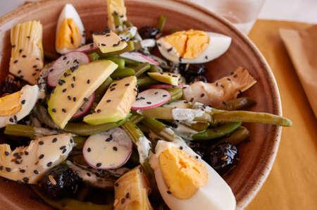 Salad with boiled eggs, avocado, green beans and black sesameの写真素材
