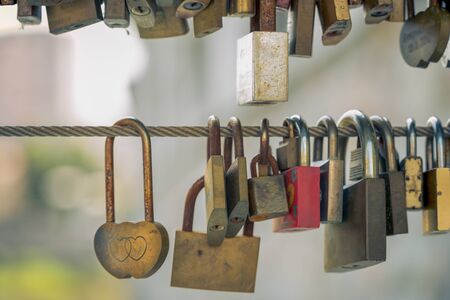 locked heart lock with a heart and a lot of other locks on the bridge, as a sign of everlasting love.の写真素材