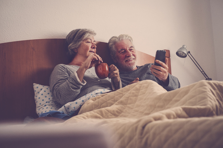 senior couple wake up with breakfast and telephoneの写真素材