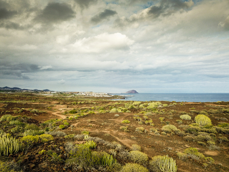 ocean view from countryside in tropical area. cacus and grass plants in arid ground. weather change. beautiful sky with clouds and sea coastline image for touristi pourpuosesの写真素材