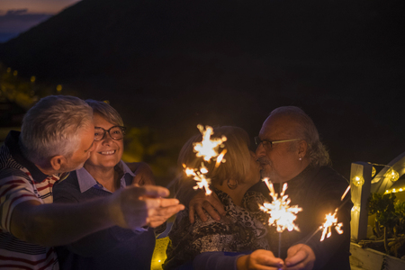 two couple kiss and celebrate event like birthday or new year eve outdoor with sparkles. happiness and hope for the future concept.の写真素材