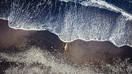 beautiful caucasian people model at the sandy beach in tenerife catching the sun while a big wave come to her.の写真素材