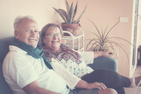 Elderly grandfather couple sitting on the sofa in the terrae. leisure nice time with fun and smiles. Vintage bright filter.の写真素材