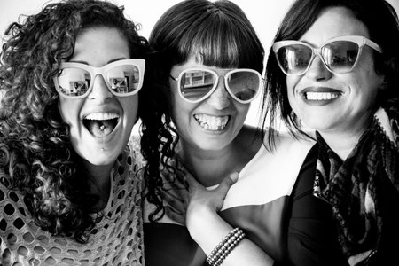 friendship for group of women people enjoy and laugh and smile together with sunglasses in craziness leisure time. funny smiles for nice beautiful ladies. group of three caucasianの写真素材