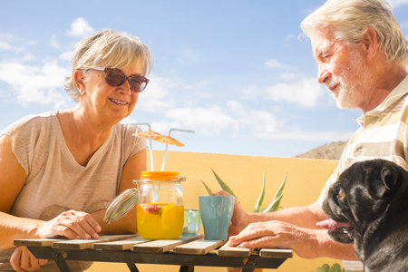 senior couple aged fruit drink on rooftop terrace with beautiful ocean view. vacation and retired conceptの写真素材