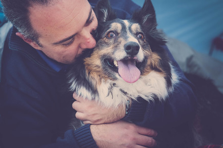 young man with border collie dog. beach camping freedom alternative vacation in Tenerife with his best friends dogの写真素材