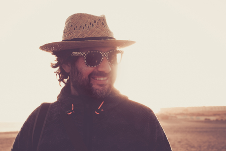 smile man look at his side in a desert portrait outdoor in tenerife. wear hat and sunglasses with backlight.の写真素材
