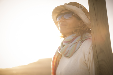 smile woman look at her side in a desert outdoor portrait in Tenerife. wear hat and scarfの写真素材