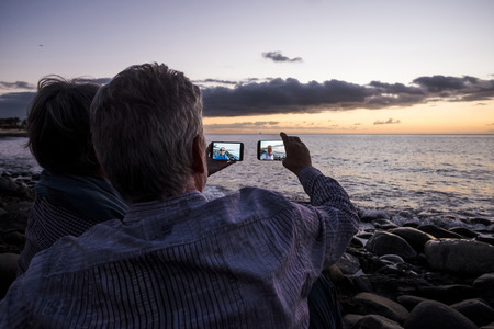 senior couple looking at camera on beach in tenerifeの写真素材