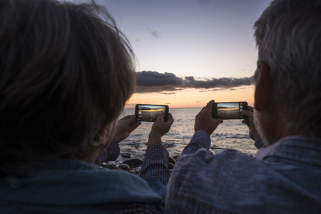 elderly couple with man and woman on the beach in sunset in Tenerifeの写真素材
