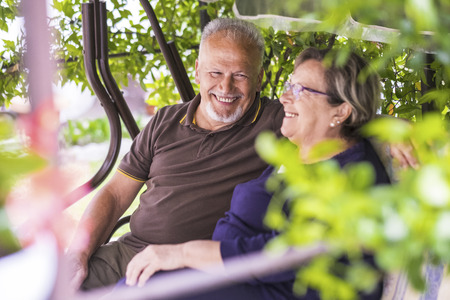 nice couple of beautiful caucasian senior 70 years old sit outdoor at home having fun with smiles and laugh. happy life together forever in love and enjoy retired time. focus on manの写真素材