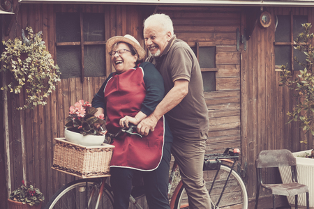 Nice caucasian people enjoy leisure outdoor both on a single bike lauhing like crazy. together funny moments at home outside. vintage filter and colors for joyful and laugh conceptの写真素材