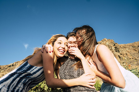 group of 25 years old girls hug and laugh together in a friendswhip teamwork. Sunny day of vacation or free time for a group. Beauty females.の写真素材
