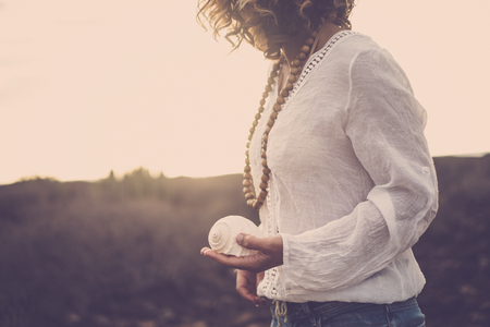 nice cut for beautiful middle age 40 years old model lady immersed in the nature of a desert. she take a shell on her hand for nature connection concept. tenerife magic place for vacationの写真素材