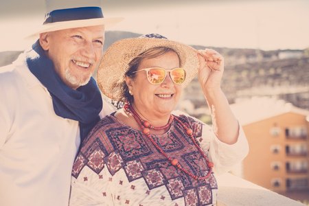 adults people on the rooftop looking the view and smile having fun under the sunlight. hats and sunglasses for enojing life concept. beautiful view.の写真素材