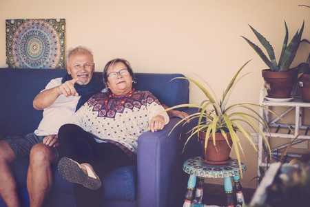 senior aged couple sit down on the sofa at home outdoor in terrace enjoyed the leisure and the lfe together forever done. smile and joy relaed looking at cameraの写真素材