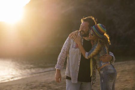 nice caucasian family couple enjoy the leisure time together during the sunset at the beach. vacation and lifetime happy two people concept. golden tones colorsfor outdoor natural scenic place and happy man and womanの写真素材