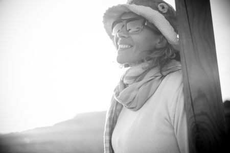 black and white summer portrait of a beautiful woman with long hair looking at the sky. Nice hats and smile.の写真素材