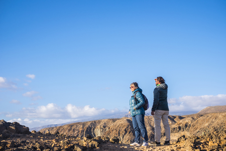 Senior mother and 45 year old son spend time together walking on an isolated pathの写真素材