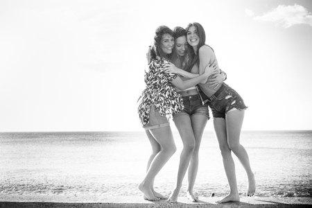 group of 25 years old girls hug and laugh together in a friendswhip teamwork. Sunny day of vacation or free time for a group. Beauty females.の写真素材