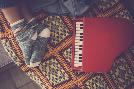caucasian feet of middle age woman sleeping at home with little red piano music near her. background and textures in vintage look. lifestyle relax conceptの写真素材