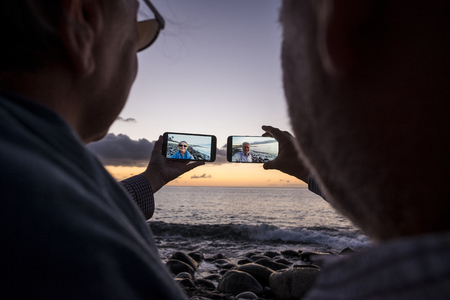 senior retired couple taking photo at sunsetの写真素材