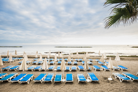 nobody at the beach un empty clients summer business. many seats and closed umbrellas in tropical summer place. vacation and relax concept with seats background and quiet oceanの写真素材