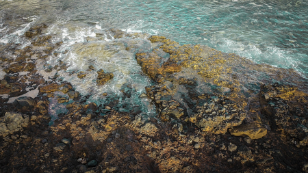 beautiful aerial view of ocean wave. blue colors and white foam on a live dangerous water with the rocks coast line and no humanの写真素材