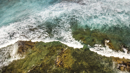 ocean's coast aerial view with blue waves and green natural rocks, vacation and adventure journey concept outdoorの写真素材