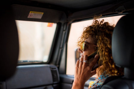 nice beautiful young woman smile and use mobile phone touching the screen inside the car while...