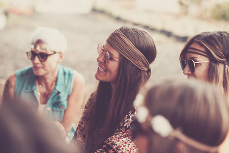 group of female girs mixed ages in celebration hippy party. smiles and happiness in friendship for women. vintage style and retro look. '70s style for nice people enjoying the leisure activityの写真素材