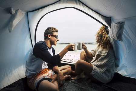mother and son in family leisure activity outdoor. travel and enjoy the camping at the beach near the sea and feeling the waves. drinking a cup of tea or coffee and live happy. alternative holiday and couple in friendship and loveの写真素材