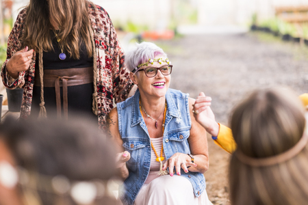 group of rock and hippy style women have fun together in a party. celebrating and smiling concept for free feminist females. mature lady enjoy the friendship and the outdoor leisure activity with peopleの写真素材