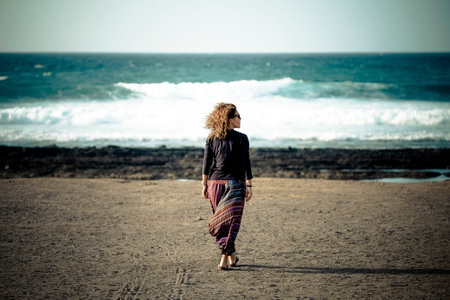 beautiful lonely caucasian middle age woman walk and enjoy the nobody beach in season. freedom and...