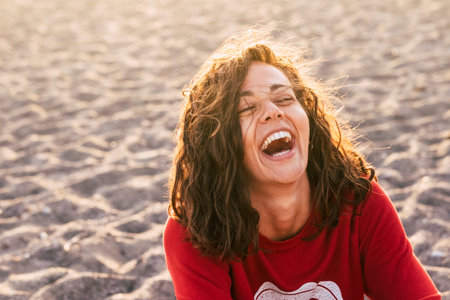 bright picture of laughing woman on the beach. backlight sunlight in background. beautiful young...