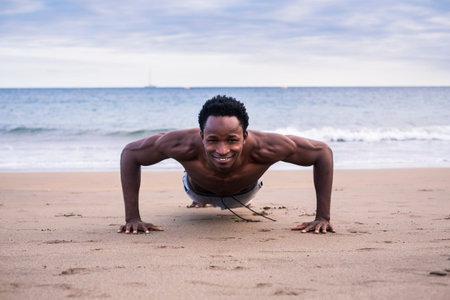 handsome nice body fitness exercises young handsome black man pushing and doing plank workout at the...
