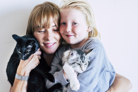 Blond mother and little child with her catsの写真素材