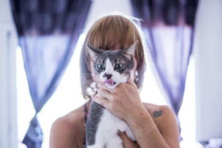 Unusual portrait of blonde woman behind her catの写真素材