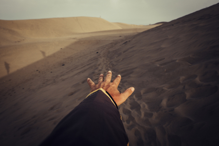 power and control and exploring travel and wanderlust concept with man hand above the dunes and desert in tropical place. i want to move and live pictures scene. People and freedom lifestyleの写真素材
